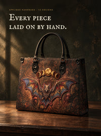 Every piece laid on by hand. The Vespertine applique handbag with a raised bat and gold moons, each piece stitched at the edge.